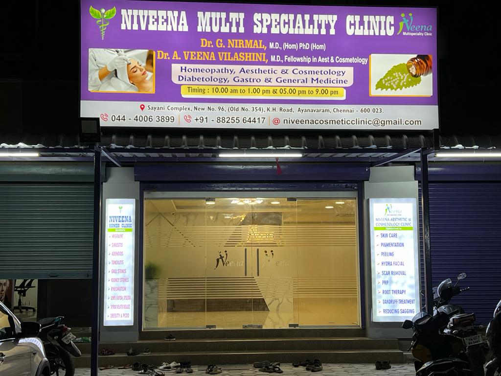 Exterior of Niveena Multi Speciality Clinic with illuminated signboard at night in Chennai