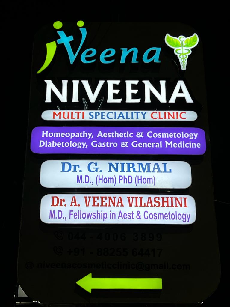 Illuminated Niveena Homeo Clinic signboard displaying the clinic name and doctors