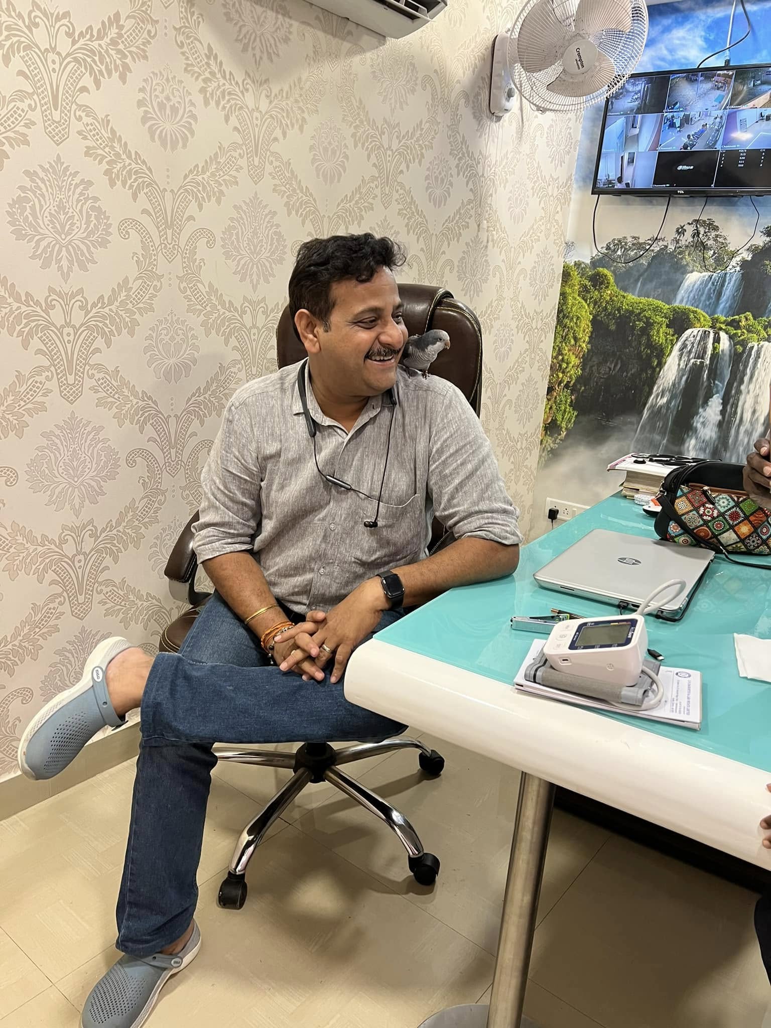 Dr. G. Nirmal seated at his desk in the consultation room at Niveena Homeo Clinic